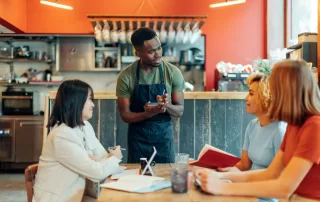 waiter taking order in a restaurant for three people